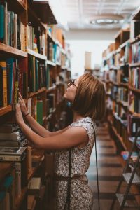 djevojka u potrazi za adekvatnom literaturom u knjiznici